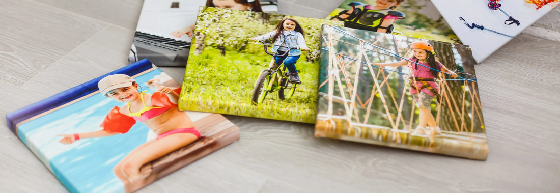 Colorful canvas prints featuring children engaged in outdoor activities, set against a light wooden background.