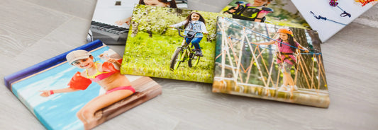 Colorful canvas prints featuring children engaged in outdoor activities, set against a light wooden background.